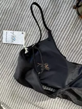 Top de bikini negro con breteles regulables y copas desmontables.