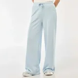 Pantalón de jogging de corte amplio y tiro medio, confeccionado en algodón de color celeste. Presenta cintura elástica con cordón de ajuste y bolsillos laterales.