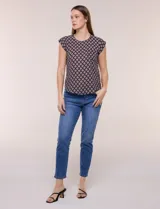 Blusa de gasa ligera con diseño geométrico en tonos oscuros, escote redondo, mangas cortas y bolsillo frontal aplicado. Presenta un ruedo redondeado y silueta relajada.