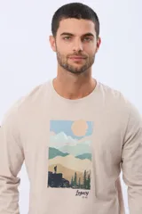 Remera de manga larga color beige con cuello redondo y estampa frontal de paisaje montañoso con la inscripción Legacy Est. 1972.