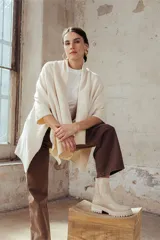 Bota tipo chelsea de caña media en color beige, con suela track dentada y paneles laterales elásticos acanalados.