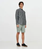 Camisa de manga larga de la marca Ripping, confeccionada en 100% algodón de color gris melange. Cuenta con cuello camisero, cierre frontal de botones, puños abotonados y un bolsillo aplicado en el pecho con cierre de botón.