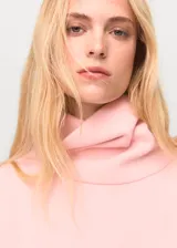 Jersey de punto color rosa, con cuello alto, manga corta y diseño recto.