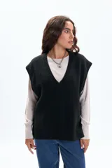 Chaleco de punto color negro, con escote en V y diseño holgado.