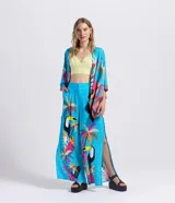 Kimono abierto de manga corta amplia, confeccionado en viscosa con estampado tropical de tucanes y palmeras sobre fondo celeste, con detalles en rosa, amarillo y negro, y terminación de flecos en los bordes.