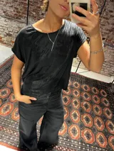 Blusa de manga corta con acabado metalizado de lúrex, cuello redondo y corte holgado.