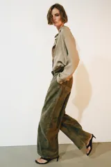 Jeans de tiro bajo y diseño barrel leg de la colección Zara Woman, en color verde militar con estampado floral en contraste, trabillas para cinturón y costuras decorativas frontales.