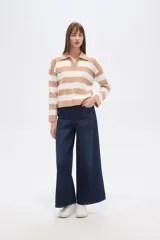 Sweater de tejido de punto con diseño de rayas horizontales en color beige y blanco, cuello polo con escote en V, manga larga y corte holgado.