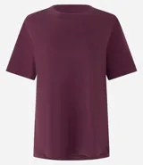 Blusa de manga corta confeccionada en algodón pima, con cuello redondo y diseño liso. Presenta un corte clásico con el bajo delantero ligeramente más largo que el posterior.