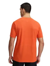 Remera deportiva Under Armour Vanish Elite Seamless de manga corta, color naranja con logo iridiscente en el pecho. Presenta un diseño sin costuras con zonas de ventilación estratégicas para mayor transpirabilidad y tecnología UA RUSH para reflejar la energía corporal.