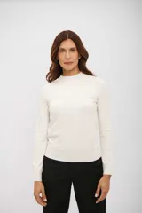 Polera de manga larga color blanco hueso, con cuello simulado (mock neck) y tejido de punto fino.