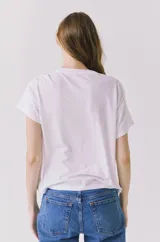 Remera blanca de manga corta y cuello redondo, con estampa frontal de paisaje costero mediterráneo con palmeras y sol, y la inscripción 'Costa del Sol'.