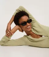 Cardigan de punto color verde claro, de manga larga y corte regular, con escote redondo y cierre frontal de botones.