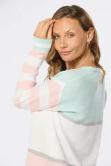 Buzo de tejido fino con rayas horizontales en tonos rosa, blanco y celeste, confeccionado en algodón.