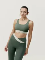 Top deportivo de sujeción media color verde militar con banda inferior color beige. Diseño reversible con tirantes anchos y espalda cruzada.