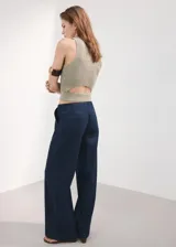Jeans Avery de corte wide leg y tiro medio, con diseño largo, bolsillos laterales y traseros, y cierre oculto con botón, gancho y cremallera.