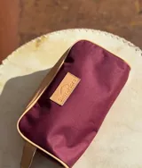 Neceser de lona verde con detalles en cuero color beige y etiqueta con logo de la marca Sierra Mora.