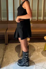 Botas de cuero negro de caña alta con hebillas plateadas y suela de goma.