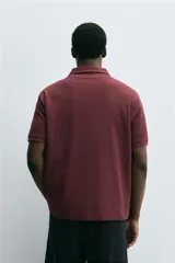 Polo de hombre color verde oliva, de corte regular fit, con cuello solapa y cierre frontal de botonadura. Presenta manga corta y acabados en rib.