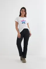 Remera blanca de algodón con mangas cortas y dobladillo. Estampado frontal de una estrella con lentejuelas de colores.