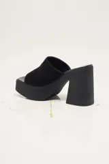 Zapato de plataforma tipo sueco, de empeine amplio en ante, con plataforma alta y taco ancho. Puntera cuadrada y diseño abierto en el talón.