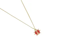 Cadena de eslabones finos con baño de oro y dije en forma de mariquita esmaltada en color rojo, con detalles de circonias incrustadas.