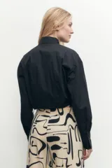 Camisa corta blanca de mangas largas con puños abotonados y cuello clásico.