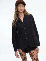 Chaqueta de pana negra con estampado a cuadros sutil, cierre frontal con botones, cuello solapa y dos bolsillos frontales de parche.
