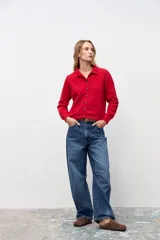 Cardigan de punto color rojo con cuello tipo polo y cierre frontal de botones. Presenta mangas largas con puños acanalados y un corte clásico.