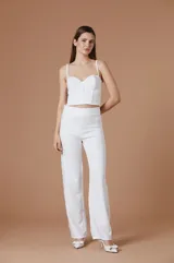 Bustier blanco de diseño estructurado con escote corazón y tirantes finos. Presenta una silueta ajustada al cuerpo con costuras verticales que realzan la figura.