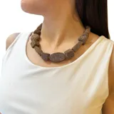 Collar corto con cuentas de hilo color marrón y dorado de diferentes formas. Largo 46cm.