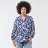 Blusa de manga larga con estampado abstracto en tonos azul y beige, cuello en pico y diseño holgado con puños elásticos.
