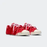 Championes Converse Chuck Taylor Lo Pro de ante premium en color rojo, con detalles de piel en el talón, puntera de goma en tono marfil y cordones intercambiables en color rosa y rojo.