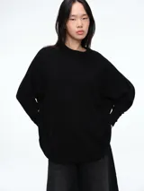 Sweater tejido de calce relajado con cuello redondo a la base y mangas largas. Presenta un diseño minimalista y versátil, ideal para combinar en múltiples ocasiones.