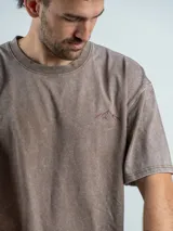 Remera oversize de algodón color negro con efecto lavado. Presenta un estampado gráfico en la espalda con la frase 'Freeze the moment' y un diseño de cámara fotográfica en tonos rojizos.