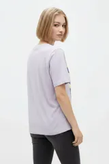 Remera de algodón de manga corta, color blanco, con cuello redondo y estampa frontal de diseño ilustrativo en tonos marrones y fucsia.