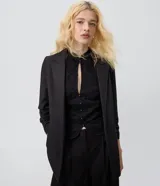 Blazer sastrero alargado color bordó de Blue Steel, confeccionado en poliéster con elastano y forro de poliéster. Presenta solapas clásicas, mangas largas fruncidas y diseño estructurado.