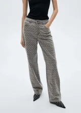 Jeans de tiro medio con diseño recto y cinco bolsillos. Presenta un acabado en color gris con detalle de strass aplicado en toda la superficie.