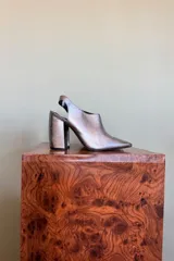 Zapatos slingback de tacón ancho y punta fina, color plateado con acabado metalizado.