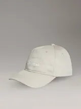 Gorra de béisbol color beige claro con logo de Calvin Klein bordado en blanco en el frente.