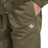 Pantalón deportivo Adidas color verde oliva, con cintura elástica, bolsillos laterales y las icónicas tres tiras blancas en la parte inferior de las piernas. Presenta el logo del trébol bordado en la pierna izquierda.