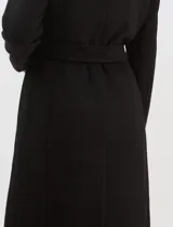 Tapado largo de paño color negro con cuello solapa amplio, cierre frontal con botones y lazo de ajuste en la cintura. Cuenta con bolsillos laterales y forro interno a tono.
