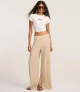 Pantalón texturizado marrón de corte ancho con cintura elástica y bolsillos laterales.