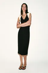 Vestido midi de escote en pico y diseño sin mangas con hombreras en contraste color crema. Presenta cintura entallada con frunces laterales, cierre trasero con cremallera oculta y abertura en el bajo de la espalda.