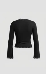 Remera negra de manga larga con escote profundo en V y detalle de puntilla en el borde del escote, puños y ruedo. Presenta un diseño ajustado al cuerpo con mangas acampanadas.