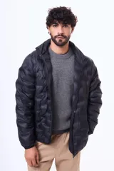 Campera puffer negra con diseño termosellado, cuello alto y cierre frontal completo. Confeccionada en nylon, ofrece ligereza y protección.