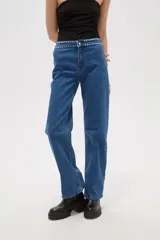 Pantalon de jean azul de corte recto y tiro alto, con detalle de tachas metálicas en la cintura.