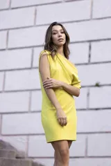 Vestido corto color lima, con escote asimétrico y manga corta.