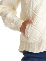 Campera combinada Current Air, con torso acolchado en diseño de rombos y mangas de tejido de punto grueso con diseño de ochos. Presenta cierre frontal metálico, cuello alto y puños y ruedo acanalados.