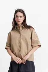Camisa color beige de manga corta con cuello clásico y corte oversize.